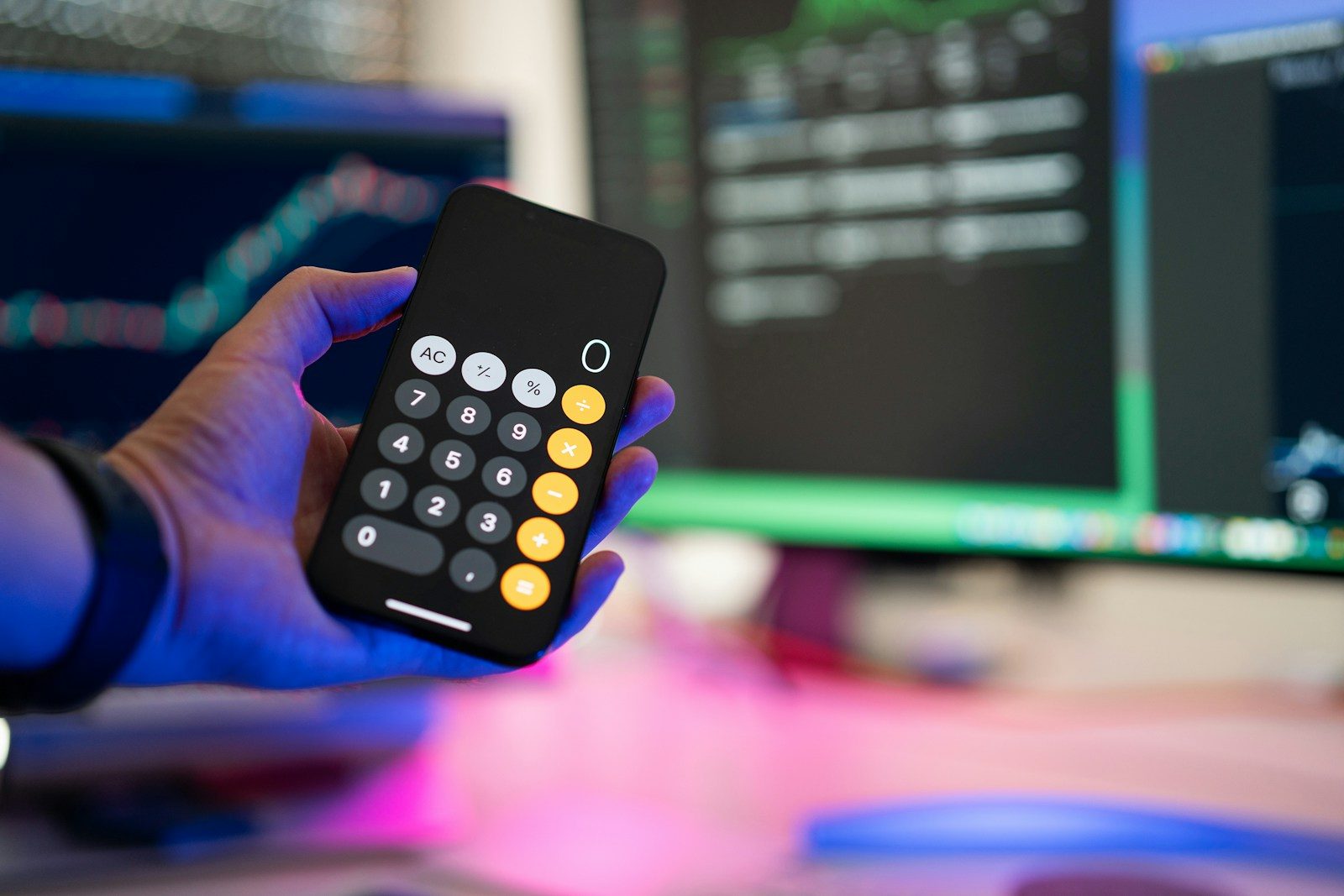 a person holding a remote control in front of a computer
