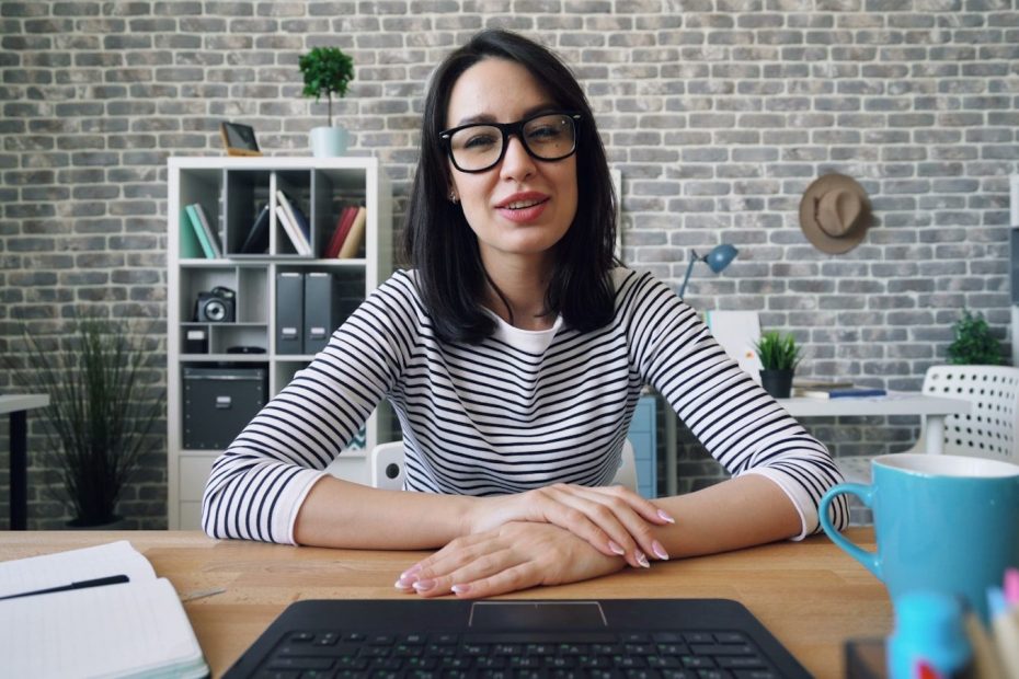 a woman sitting at a desk in front of a laptop