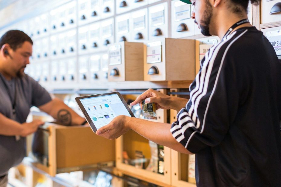 two men in a store looking at a tablet