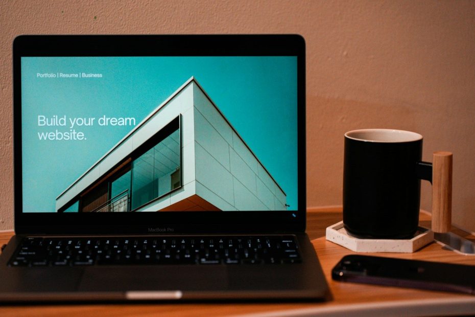 a laptop computer sitting on top of a wooden desk