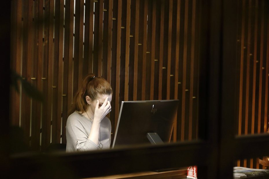 a woman sitting in front of a laptop computer